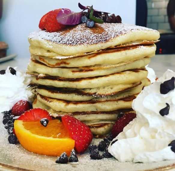 Breakfast at Bread and Butter Truro, including their pancake stack with lots of cream and berries