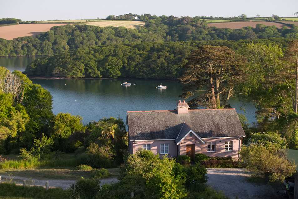 Drone image of holiday home Lorelei on the Helford River, with trees and the creek