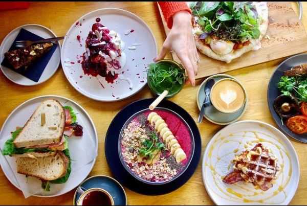 A table pf breakfast options at Slice Cornwall including acia bowls, waffles, coffee and breakfast sandwiches