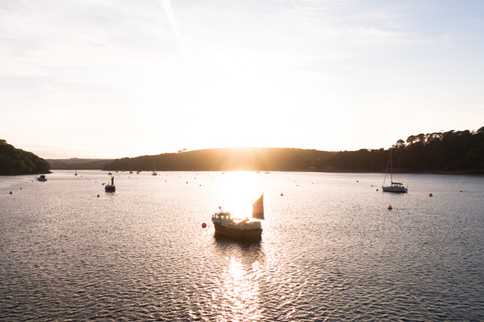 A small fishing boat on the Helford River at sunset