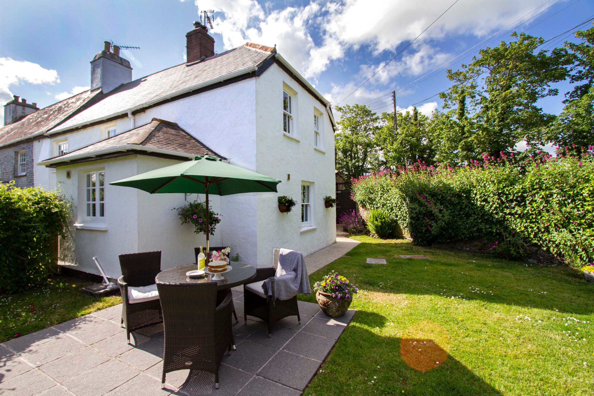 The outside of Trerose Farm Cottage with patio area and outdoor seating